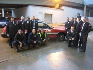 Group of firefighters with emergency vehicle